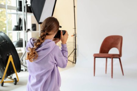 Foto de Fotógrafa tomando foto de silla en estudio - Imagen libre de derechos