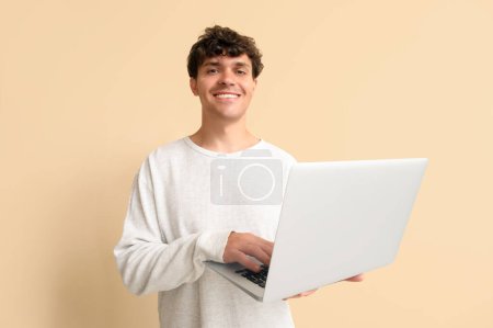 Photo for Male programmer working with laptop on beige background - Royalty Free Image