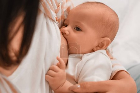 junge Frau stillt ihr Baby im Schlafzimmer, Nahaufnahme