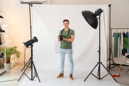 Foto de Fotógrafo masculino con cámara en estudio - Imagen libre de derechos