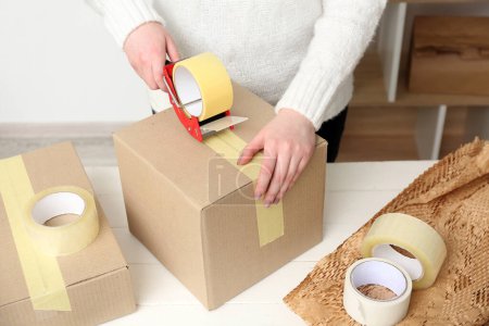 Foto de Caja de cartón de embalaje para mujer con dispensador de cinta adhesiva - Imagen libre de derechos