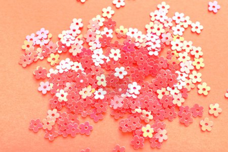 Photo for Heap of star shaped sequins on coral background, closeup - Royalty Free Image