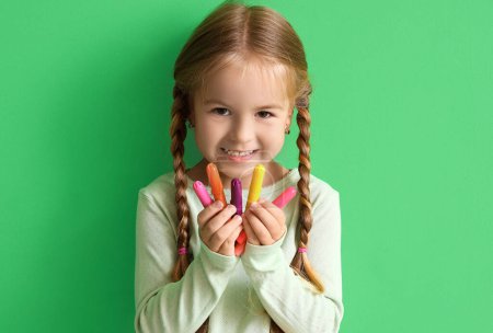 Téléchargez les photos : Petite fille mignonne avec feutre stylos sur fond vert - en image libre de droit