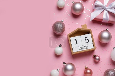 Komposition mit Countdown-Kalender, Weihnachtskugeln und Geschenkbox auf rosa Hintergrund