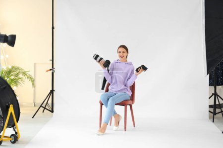 Foto de Fotógrafa femenina con cámara trabajando en estudio - Imagen libre de derechos