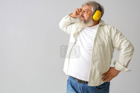 Foto de Retrato del hombre mayor en protectores auditivos sobre fondo gris. Fiesta del Día del Trabajo - Imagen libre de derechos