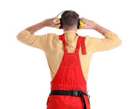 Foto de Trabajador maduro en protectores auditivos sobre fondo blanco, vista posterior. Fiesta del Día del Trabajo - Imagen libre de derechos