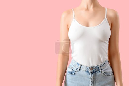 Téléchargez les photos : Jeune femme en haut et jeans sur fond rose - en image libre de droit