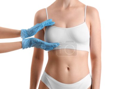 Téléchargez les photos : Chirurgien plastique touchant le sein de la femme sur fond blanc - en image libre de droit