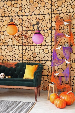 Photo for Interior of living room decorated for Halloween with green sofa and ladder - Royalty Free Image