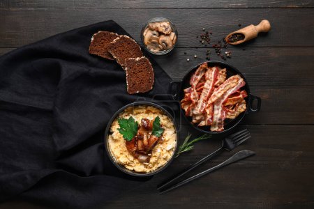 Téléchargez les photos : Bol de banosh savoureux, pain, champignons et bacon sur fond de bois noir - en image libre de droit