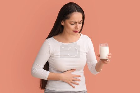 Téléchargez les photos : Jeune femme mécontente avec intolérance au lactose sur fond beige - en image libre de droit