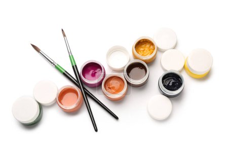Téléchargez les photos : Pots de peintures à la gouache colorées avec des pinceaux sur fond blanc - en image libre de droit