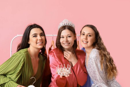 Photo for Young women with tiaras for prom on pink background - Royalty Free Image