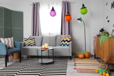 Photo for Interior of light living room decorated for Halloween with sofa and pumpkins - Royalty Free Image