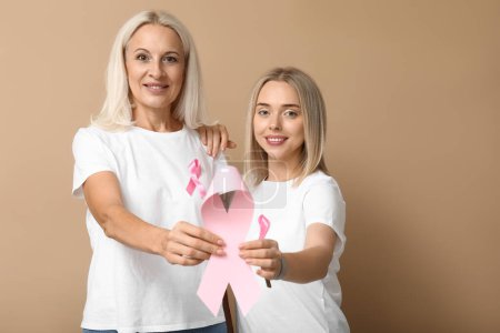 Frauen mit rosa Schleife auf beigem Hintergrund. Brustkrebs-Aufklärungskonzept