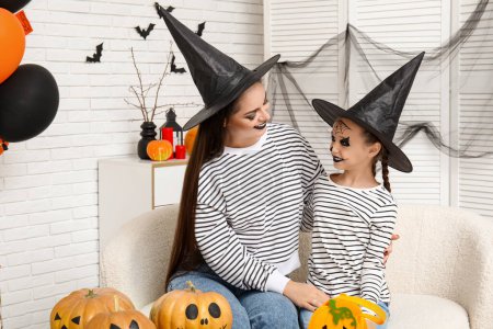 Photo for Little girl with her mother in witch hats celebrating Halloween at home - Royalty Free Image