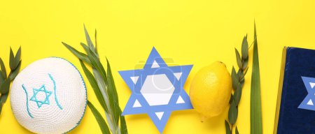 Foto de Cuatro especies (lulav, hadas, arava, etrog) como símbolos del festival Sukkot, kippah, torá y papel estrella David sobre fondo amarillo - Imagen libre de derechos