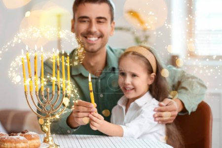 Happy father and daughter lighting candles for Hannukah at home