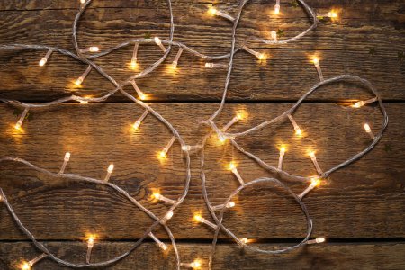 Photo for Glowing Christmas lights on wooden background - Royalty Free Image