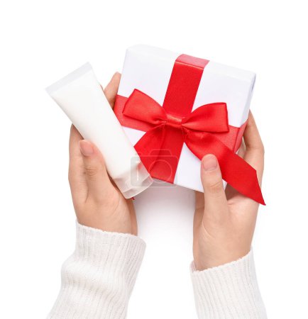 Téléchargez les photos : Mains féminines avec cadeau de Noël et produit cosmétique sur fond blanc, gros plan - en image libre de droit