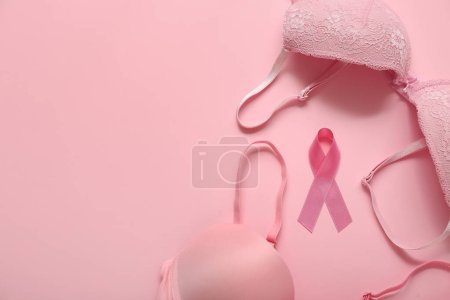 Foto de Cinta rosa con sujetadores sobre fondo de color. Concepto de conciencia sobre el cáncer de mama - Imagen libre de derechos