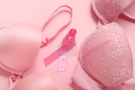 Foto de Cinta rosa con sujetadores sobre fondo de color, primer plano. Concepto de conciencia sobre el cáncer de mama - Imagen libre de derechos