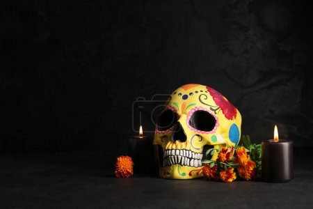 Flores de caléndula con velas y cráneo pintado sobre fondo negro. Celebración del Día de Muertos de México (El Día de Muertos))