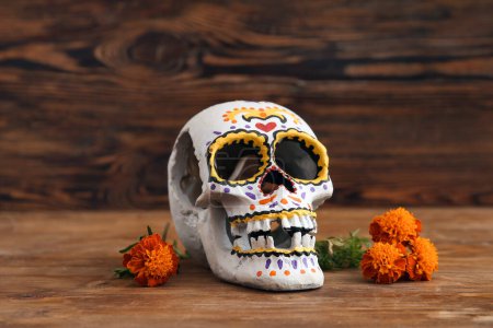 Téléchargez les photos : Fleurs de souci avec crâne peint sur fond de bois brun. Célébration de la fête des morts du Mexique (El Dia de Muertos) - en image libre de droit