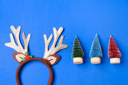 Foto de Lindos cuernos de reno de Navidad con decoración sobre fondo azul - Imagen libre de derechos