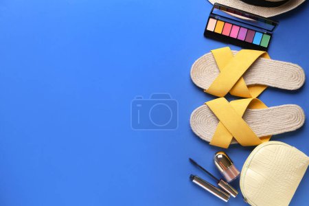 Téléchargez les photos : Composition avec des sandales féminines élégantes et des cosmétiques sur fond bleu - en image libre de droit