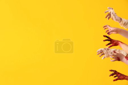 Téléchargez les photos : Zombie et momie mains sur fond jaune. Fête d'Halloween - en image libre de droit