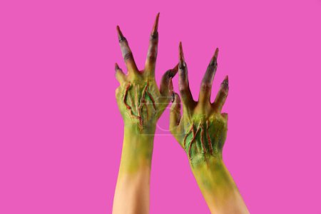 Téléchargez les photos : Mains de sorcière avec des griffes sur fond violet. Fête d'Halloween - en image libre de droit