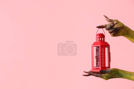 Téléchargez les photos : Sorcière avec lanterne sur fond rose. Fête d'Halloween - en image libre de droit