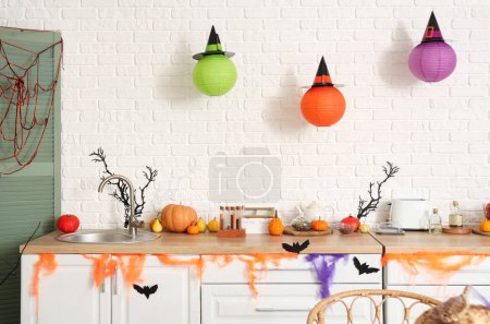Photo for Interior of light kitchen decorated for Halloween with counters and pumpkins - Royalty Free Image
