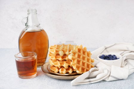 Photo for Plates of tasty waffles with blueberries and maple syrup on white background - Royalty Free Image