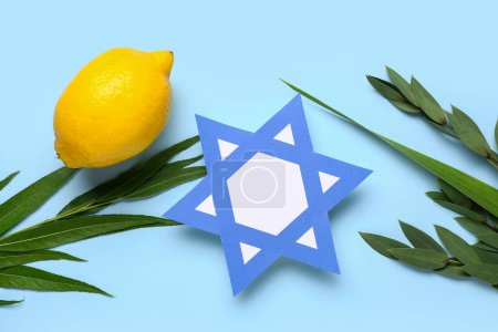 Foto de Cuatro especies (lulav, hadas, arava, etrog) como símbolos del festival Sukkot y papel estrella David sobre fondo azul - Imagen libre de derechos