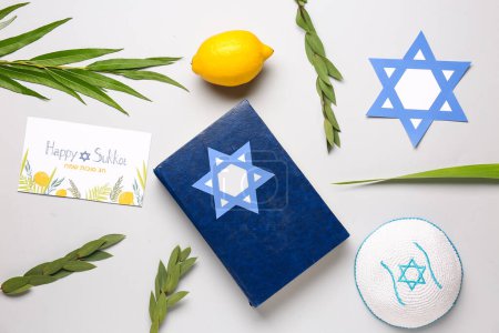 Foto de Composición del festival Sukkot con cuatro especies (lulav, hadas, arava, etrog), Torá y tarjeta de felicitación sobre fondo gris - Imagen libre de derechos