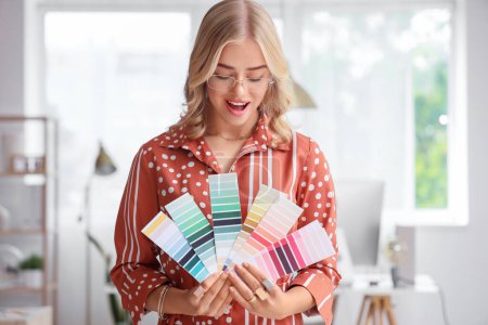 Téléchargez les photos : Designer d'intérieur féminin avec palettes de couleurs au bureau - en image libre de droit