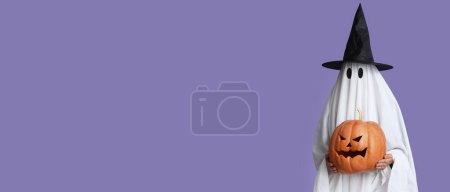 Téléchargez les photos : Femme en costume de fantôme sorcière tenant citrouille Halloween sur fond lilas avec de l'espace pour le texte - en image libre de droit