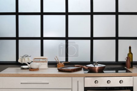 Téléchargez les photos : Comptoirs de cuisine avec cuisinière électrique, four, poêle à frire et planche à découper - en image libre de droit
