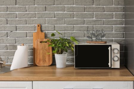 Téléchargez les photos : Comptoir de cuisine avec four micro-ondes, plante d'intérieur et planches à découper - en image libre de droit
