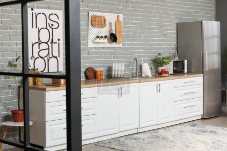 Téléchargez les photos : Intérieur de la cuisine moderne avec comptoirs blancs et réfrigérateur - en image libre de droit