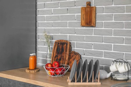 Téléchargez les photos : Comptoir en bois avec pommes, porte-assiettes et bouteilles de jus dans la cuisine moderne - en image libre de droit