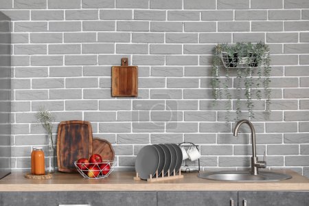 Téléchargez les photos : Comptoir en bois avec évier, pommes et porte-assiettes dans la cuisine moderne - en image libre de droit
