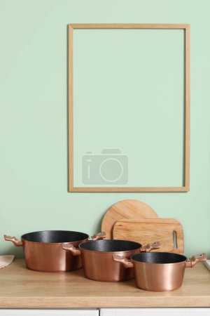 Téléchargez les photos : Comptoir en bois avec ensemble de casseroles et planches à découper dans la cuisine - en image libre de droit