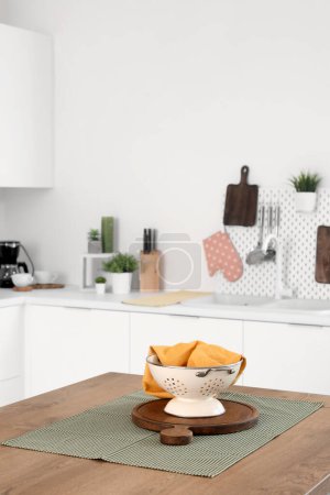 Téléchargez les photos : Table îlot en bois avec passoire et planche à découper à l'intérieur de la cuisine moderne - en image libre de droit