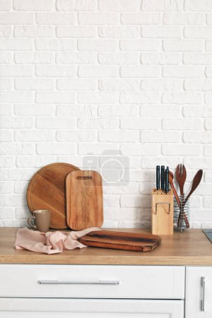 Téléchargez les photos : Comptoir de cuisine en bois avec planches à découper, tasse et ustensiles - en image libre de droit