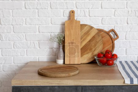Téléchargez les photos : Comptoir en bois avec planches à découper, tomates fraîches et vase - en image libre de droit