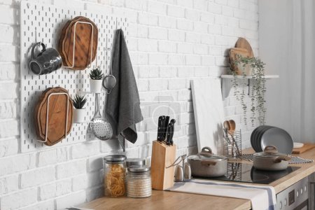 Téléchargez les photos : Pegboard avec planches à découper et ustensiles sur comptoirs en bois à l'intérieur de la cuisine moderne - en image libre de droit